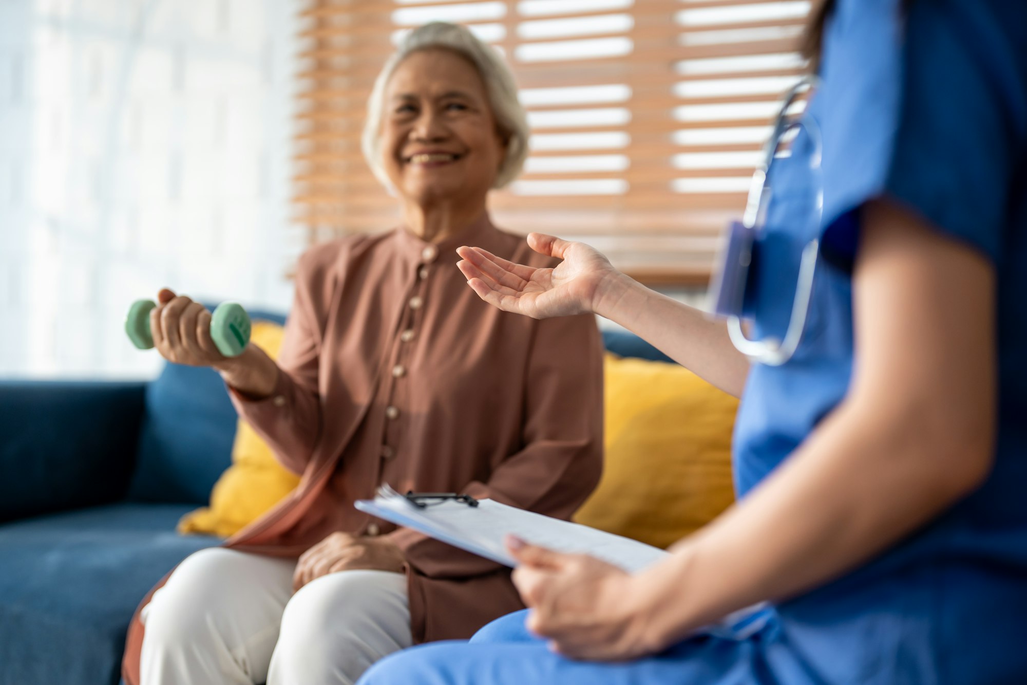 Asian senior elder woman doing physiotherapist with support from nurse.